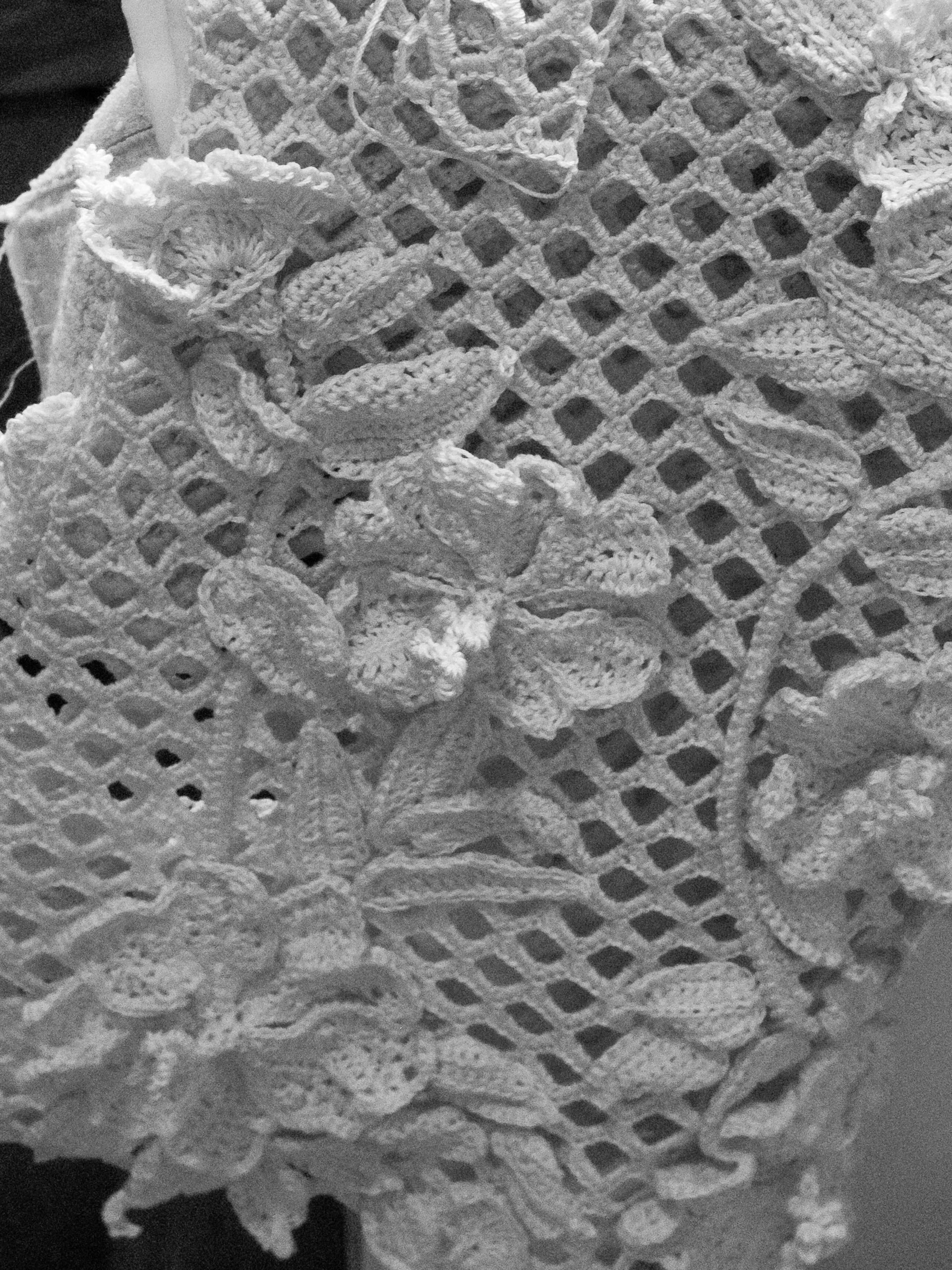 Detailed macro shot of the black and white textile development process for the Oscar De La Renta Pre-Fall 2025 Hibiscus motif crochet dress, engineered by Elite Knitting